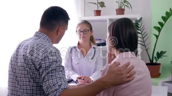 生育诊所男人在医务室接待医生时安慰他伤心的妻子视频的预览图