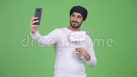 年轻的留着胡子的印度男人用纸签自拍视频的预览图