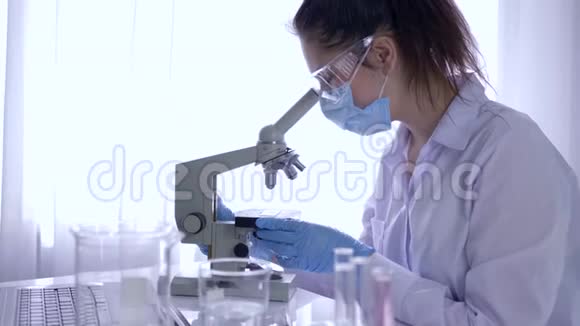科学实验室在无菌条件下用显微镜进行生物研究的妇女视频的预览图