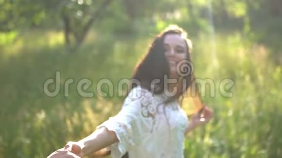 布鲁内特带着迷人的微笑以浪漫的风格在花园里散步视频的预览图