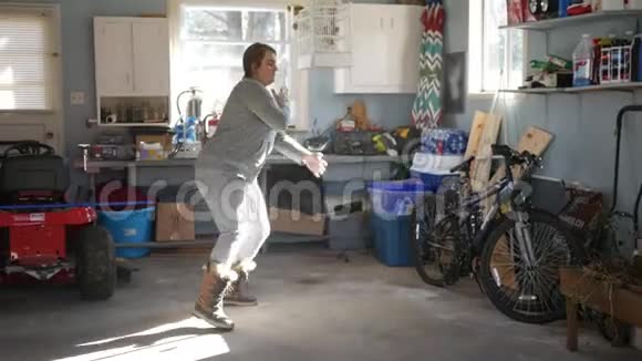 春天打扫后女人在车库里跳舞听音乐视频的预览图