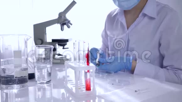 医学实验室专家妇女在无菌条件下用试管和显微镜做血液测试视频的预览图
