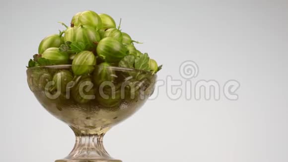 旋转玻璃花瓶与一堆绿色的鹅莓视频的预览图