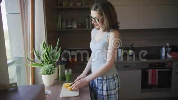有魅力的女人在厨房里切橘子视频的预览图