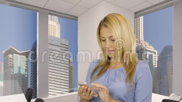 幸福的女人手里拿着手机在社交网络上浏览新闻视频的预览图
