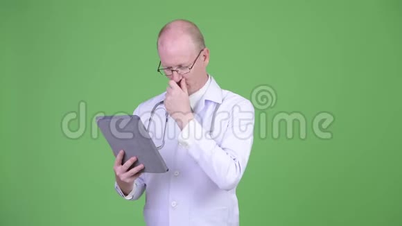 成熟秃头医生使用数码平板电脑视频的预览图