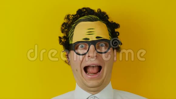 黄色墙壁背景上的尖叫滑稽卷曲的家伙积极疯狂的人类情感的肖像视频的预览图
