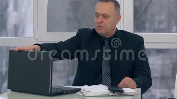 健忘的老人合上笔记本电脑脸上带着惊讶的表情去了某个地方视频的预览图