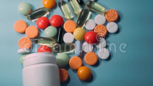 蓝色背景下的药物药丸片剂胶囊和瓶子视频的预览图