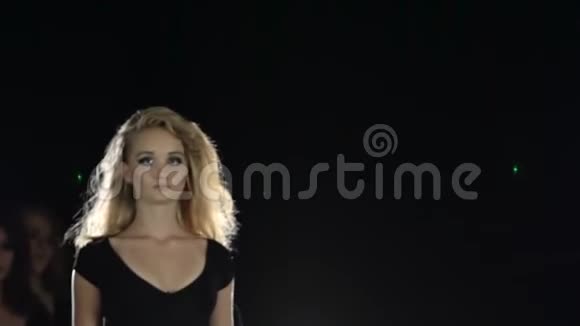 模特们展示衣服一个个走进房间的中心黑色背景慢动作视频的预览图