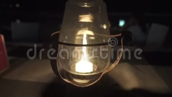 风在海边的一张街头餐馆的桌子上吹着一顶玻璃罩在蜡烛上视频的预览图