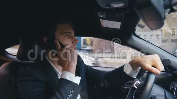 英俊的商人开着一辆车一个年轻自信的人在城市里开车的肖像视频的预览图