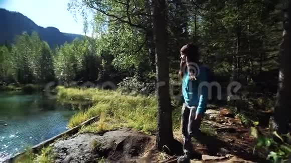 阳光明媚的一天年轻的女游客正来到美丽的蓝山湖附近滑块视频的预览图