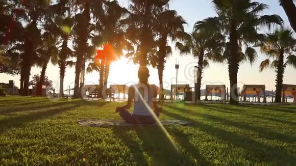 早上在公园冥想女人在海边练习瑜伽在佳能EOS5D马克IV上拍摄慢动作全高清1080视频的预览图