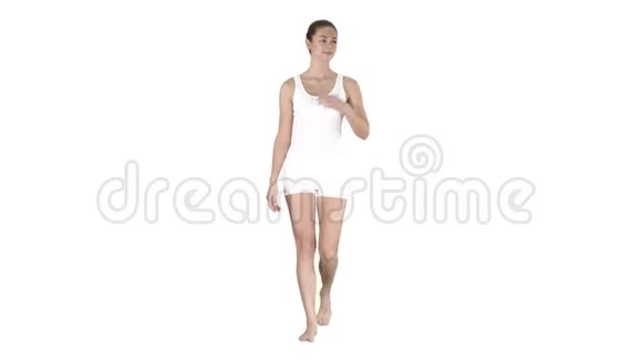 年轻的金发女人走着指着侧面展示白色背景上的东西视频的预览图