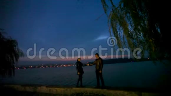 在一个夜晚城市的背景下男人亲切地拥抱和亲吻一个女孩视频的预览图