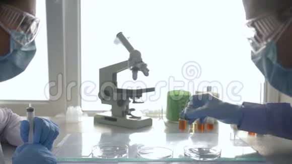 研制药物实验室人员戴上护目镜和橡胶手套对培养皿进行科学研究视频的预览图