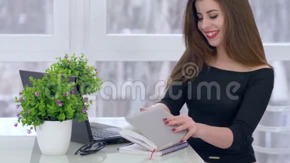 成功的女人打开笔记本准备工作坐在灯光室的桌子上视频的预览图