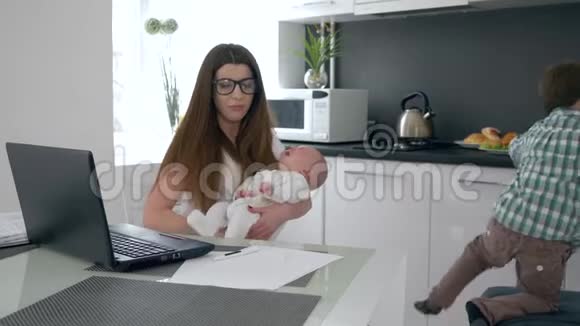 保姆抱着哭泣的婴儿在厨房工作背景是跳跃男孩视频的预览图