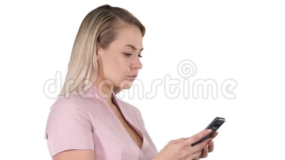 在白色背景下在智能手机上发送信息的开朗年轻女人的肖像视频的预览图