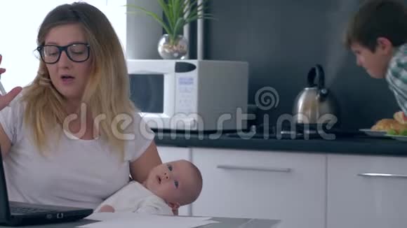 孩子干扰了商业妈妈的工作她的手里拿着一个婴儿在厨房视频的预览图