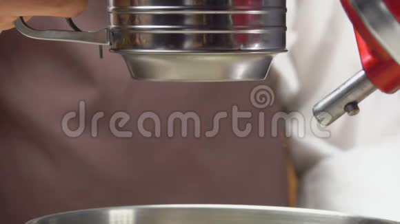 粉末状糖通过筛子筛入搅拌碗中视频的预览图