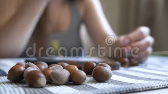 一个坐在桌子旁清洁一个菲伯特的女孩的手的特写美味健康的坚果视频的预览图