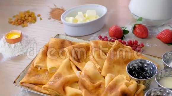 俄罗斯传统煎饼布里尼提供果酱酸奶油和草莓盘特写侧视视频的预览图