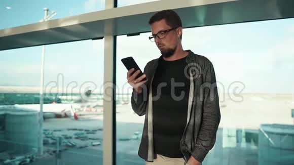 在机场用手机的年轻人视频的预览图