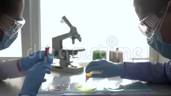制造药品实验室助理进入护目镜和橡胶手套在诊所进行化学实验视频的预览图
