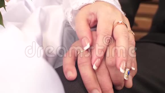 女人的手抚摸男人的手手上有结婚戒指特写视频的预览图