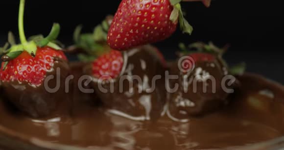 手蘸草莓加入融化的巧克力新鲜浆果甜甜点食品视频的预览图