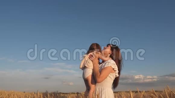 妈妈和小宝宝在熟麦地玩耍幸福的家庭旅行妈妈把一个快乐的女儿抛在天空视频的预览图