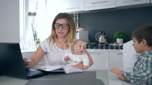 沮丧恼羞成怒的母亲抱着婴儿哭着对大儿子尖叫然后手牵着头视频的预览图