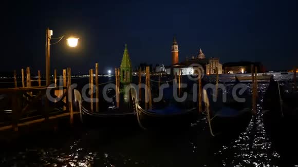 夜晚在威尼斯和遥远的圣乔乔治马吉奥尔岛上停泊的海湾视频的预览图