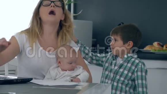 惹人厌烦的母亲骂儿子干扰工作做生意的母亲在厨房带孩子视频的预览图
