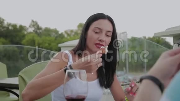 一个女人喜欢在露天露台上的餐馆吃炸鸡翅视频的预览图