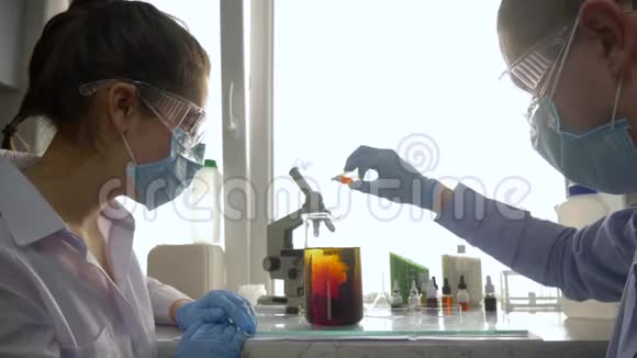 科学家在实验实验室中观察到大玻璃中与液体的化学反应视频的预览图
