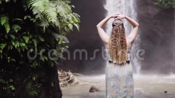 户外留着健康长发的美女幸福的年轻女子享受着狂野的自然和瀑布的力量美丽美丽视频的预览图