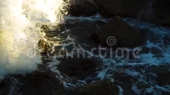 海浪以缓慢的速度撞击岩石和石块视频的预览图