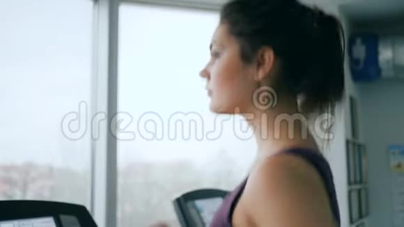 体育活动快乐女孩在健身房的跑步机上跑步特写视频的预览图