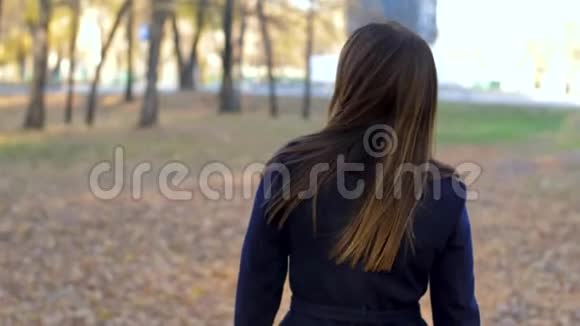 女人穿过公园转过身环顾四周转向相机4k60fps慢动作一个女孩视频的预览图