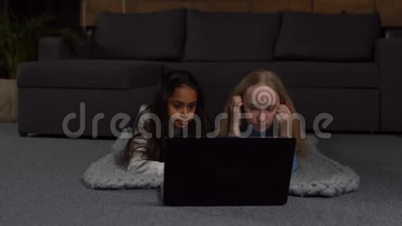 多种族的孩子在笔记本电脑上看动画片视频的预览图