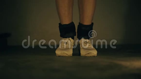 穿白色运动鞋和黑色脚踝负重的腿部特写镜头并进行增加视频的预览图