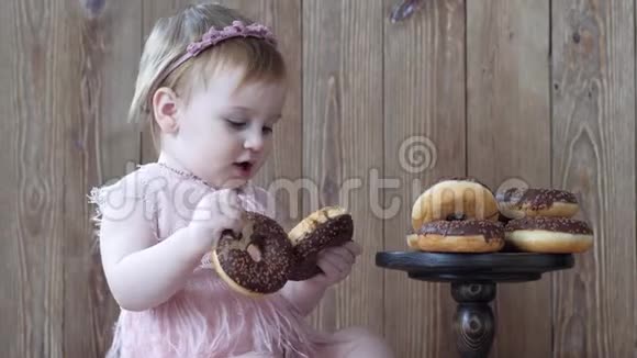 甜食孩子在木制墙上吃甜甜圈视频的预览图