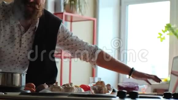 一个开朗的男人独自在厨房做饭享受这个过程视频的预览图