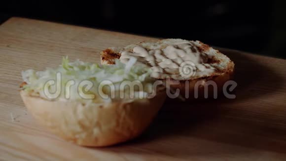 厨师做汉堡在烤架上煎包子放腌黄瓜片视频的预览图