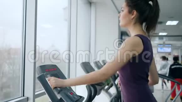 健康的生活方式女运动员在健身俱乐部使用椭圆训练器锻炼肌肉视频的预览图