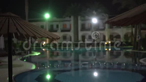 4K酒店游泳池和在夜间灯光下休息的地方视频的预览图