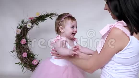 幸福的家庭休闲年轻的母亲花时间和穿着粉红色衣服的婴儿到房间里视频的预览图